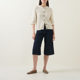 Model wearing InWear Glenn Culotte Jeans in Dark Denim, wide-leg cropped fit, styled with cream cable-knit cardigan and tan loafers.