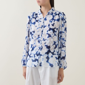 Model wearing InWear Cielle Illuminating Florals Blouse in Blue Blurr, long sleeves, standing collar, styled with white trousers