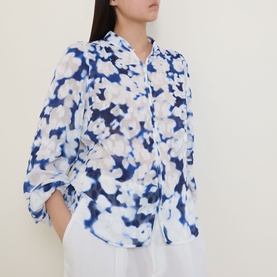Model wearing InWear Cielle Illuminating Florals Blouse in Blue Blurr, standing collar, button front, long sleeves, styled with white trousers