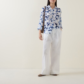 Model wearing InWear Cielle Illuminating Florals Blouse in Blue Blurr, styled with white wide-leg trousers and a brown shoulder bag.