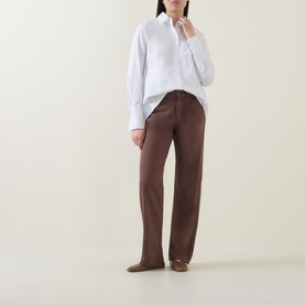 Model wearing InWear Vex Pleated Shirt in Pure White with pointed collar and long sleeves, styled with brown wide-leg trousers.