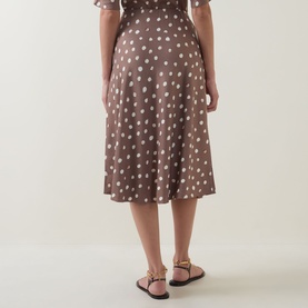 Model wearing InWear brown polka dot midi skirt, rear view, styled with flat strappy sandals