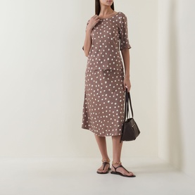 Model wearing InWear Brown Bru polka dot midi skirt styled with matching top, carrying black bag, wearing brown strappy flat sandals.