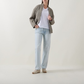 Model wearing InWear Gudrun Puff T-Shirt in Pure White with grey quilted jacket, light wash straight-leg jeans and beige loafers.