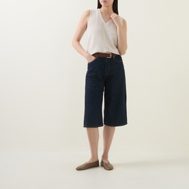 Model wearing InWear Deva Knitted Vest in Ecru with dark navy wide-leg cropped denim and tan belt, styled with nude flat shoes.