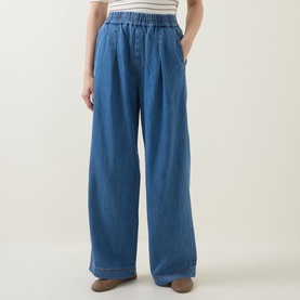Model wearing InWear Glenn Pleated Denim Trousers in Faded Blue, wide-leg with elasticated waist, front pleats and tobacco stitching.