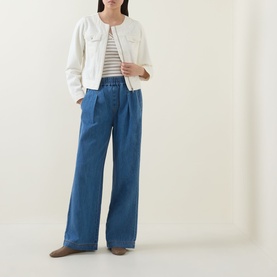 Model wearing InWear Glenn Pleated Denim Trousers in Faded Blue, wide-leg with front pleats, styled with white jacket and striped top.