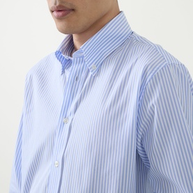 Model wearing Kempt Stripe Single-Cuff Shirt in blue and white, featuring button-down collar and classic stripe pattern. 100% cotton.