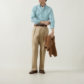 Model wearing Kempt Green White Stripe Single-Cuff Shirt with beige pleated trousers and brown leather belt, carrying a tan jacket.