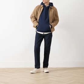 Model wearing Levi's dark blue jeans with a navy hoodie, tan jacket and white trainers.