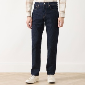 Model wearing Levi's dark blue straight-leg jeans in cotton blend, styled with cream knit top and white trainers.