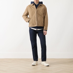 Model wearing Levi's dark blue jeans styled with a tan jacket, white T-shirt and cream trainers.