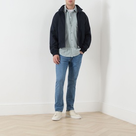 Model wearing Levi's 511 Slim Leg Jeans in A Step Ahead blue, styled with a navy zip hoodie, light blue shirt and white trainers.