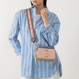 Model carrying Marc Jacobs The Colourblock Chain Snapshot crossbody in Rose Multi, gold-toned hardware, branded web strap, worn over striped shirt.
