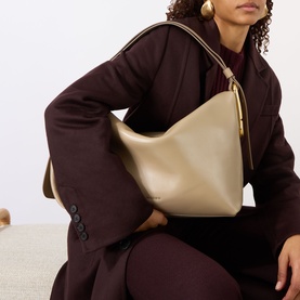 Model carrying Marc Jacobs The Scene Large Shoulder Bag in light slate smooth leather with gold-tone hardware, styled with a burgundy coat