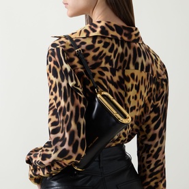 Model carrying Marc Jacobs Scene Small Shoulder Bag in black leather with gold-toned hardware, styled with a leopard print blouse.
