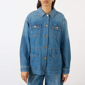 Model wearing Paige denim jacket in La Verne blue with gold buttons, chest pockets, and patch pockets, styled with matching wide-leg jeans.