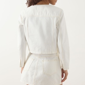 Model wearing Paige jacket in Toasted Ecru, rear view, 100% cotton with seam detailing, styled with matching mini skirt.
