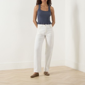 Model wearing Paige Pacific Blue tank top with square neckline, styled with white straight-leg jeans and taupe mules.