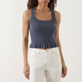Model wearing Paige Pacific Blue ribbed knit tank with frill hem and square neckline, styled with white jeans.