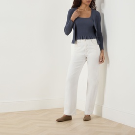Model wearing Paige Pacific Blue tank with square neckline and peplum hem, styled with white wide-leg jeans and taupe mules.