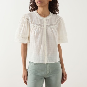 Model wearing Paige ivory cotton blouse with puff sleeves, lace trim detail, and front pleat, styled with sage green jeans.