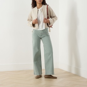 Model wearing Paige ivory cotton top with wide-leg sage green trousers, cream bomber jacket, and taupe loafers