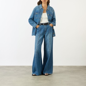 Model wearing Paige Wide Leg Jeans in La Verne denim, styled with matching denim shirt and white top, black belt.