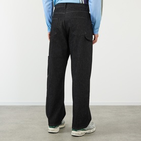 Model wearing Robyn Lynch Technical Denim Jeans in black, straight-leg fit with side patch pocket and carpenter loop, styled with chunky trainers.