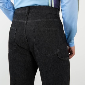 Model wearing Robyn Lynch Technical Denim Jeans in black, showing rear five-pocket detail, carpenter loop and tonal stitching on dark wash denim.