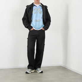 Model wearing Robyn Lynch Technical Denim Jeans in black, straight-leg with carpenter loop, styled with black zip jacket and blue graphic tee.
