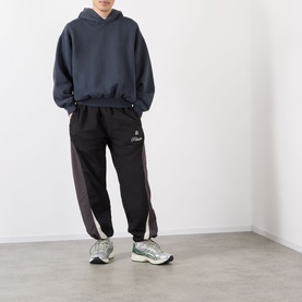 Model wearing Robyn Lynch slate blue cotton hoodie, styled with black joggers and grey chunky trainers.