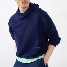 Model wearing Robyn Lynch Ireland Logo Embroidered Polar Fleece Hoodie in navy, with mint green layered hem visible beneath.