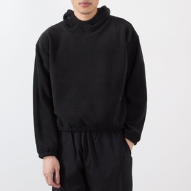 Model wearing Robyn Lynch black polyester sweatshirt with elasticated hem and high neck, styled with matching black trousers.