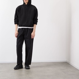 Model wearing Robyn Lynch black polyester hoodie sweatshirt with matching black trousers and black trainers.