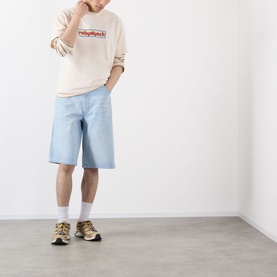 Model wearing Robyn Lynch Logo Graphic T-Shirt in off white, styled with light blue denim shorts, white socks and tan trainers.
