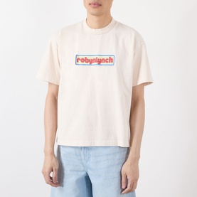 Model wearing Robyn Lynch Logo Graphic T-Shirt in off white with chest logo graphic, styled with light blue jeans.
