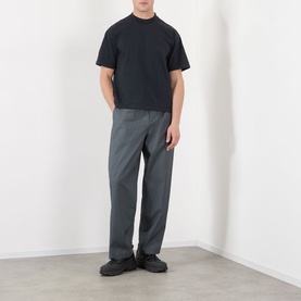 Model wearing Robyn Lynch Eire Logo T-Shirt in off black with grey tailored trousers and black chunky trainers.