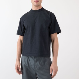 Model wearing Robyn Lynch Eire Logo T-Shirt in off black, round neck, short sleeves, styled with grey striped trousers