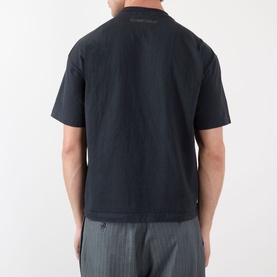 Model wearing Robyn Lynch Eire Logo T-Shirt in off black cotton, rear view, with grey striped trousers.