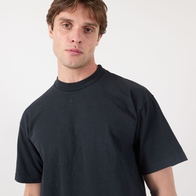 Model wearing Robyn Lynch Eire Logo T-Shirt in off black, featuring a mock neck, short sleeves, and relaxed fit in 100% cotton.