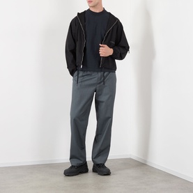 Model wearing Robyn Lynch Eire Logo T-Shirt in Off Black, styled with black zip hoodie, grey trousers and black chunky trainers.