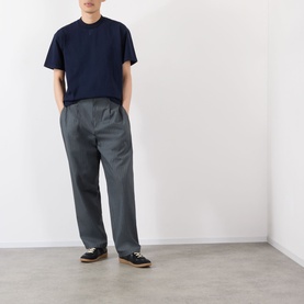Model wearing Robyn Lynch navy cotton T-shirt with henley neckline, styled with grey wide-leg trousers and black trainers.