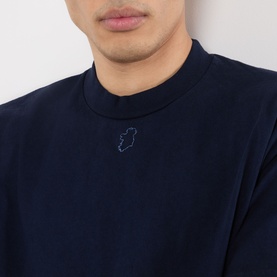 Model wearing Robyn Lynch navy cotton T-shirt with mock neck collar and small tonal chest emblem embroidery.