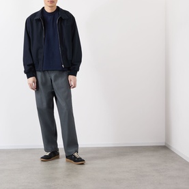Model wearing Robyn Lynch navy cotton T-shirt, styled with dark zip-up jacket, grey trousers and black shoes.