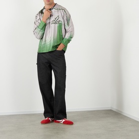 Model wearing Robyn Lynch green gradient zip-up jacket with black cargo trousers and red trainers