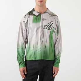 Model wearing Robyn Lynch green and grey printed long-sleeve top with hood detail and graphic logo, styled with dark trousers.