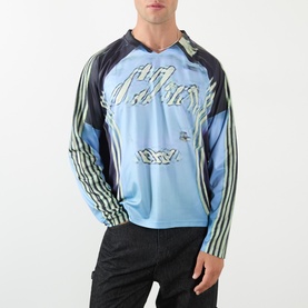 Model wearing Robyn Lynch blue long-sleeve graphic jersey top with black and white stripe sleeves and script logo print.