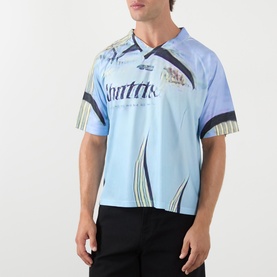 Model wearing Robyn Lynch off black T-shirt in light blue graphic football-style jersey with logo print, paired with black trousers