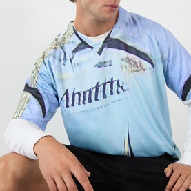 Model wearing Robyn Lynch off black long-sleeve graphic football jersey with light blue print and zip collar, styled with dark shorts